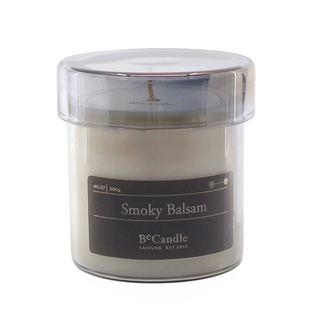 Candle in a glass jar labeled 'Smoky Balsam' on a white background