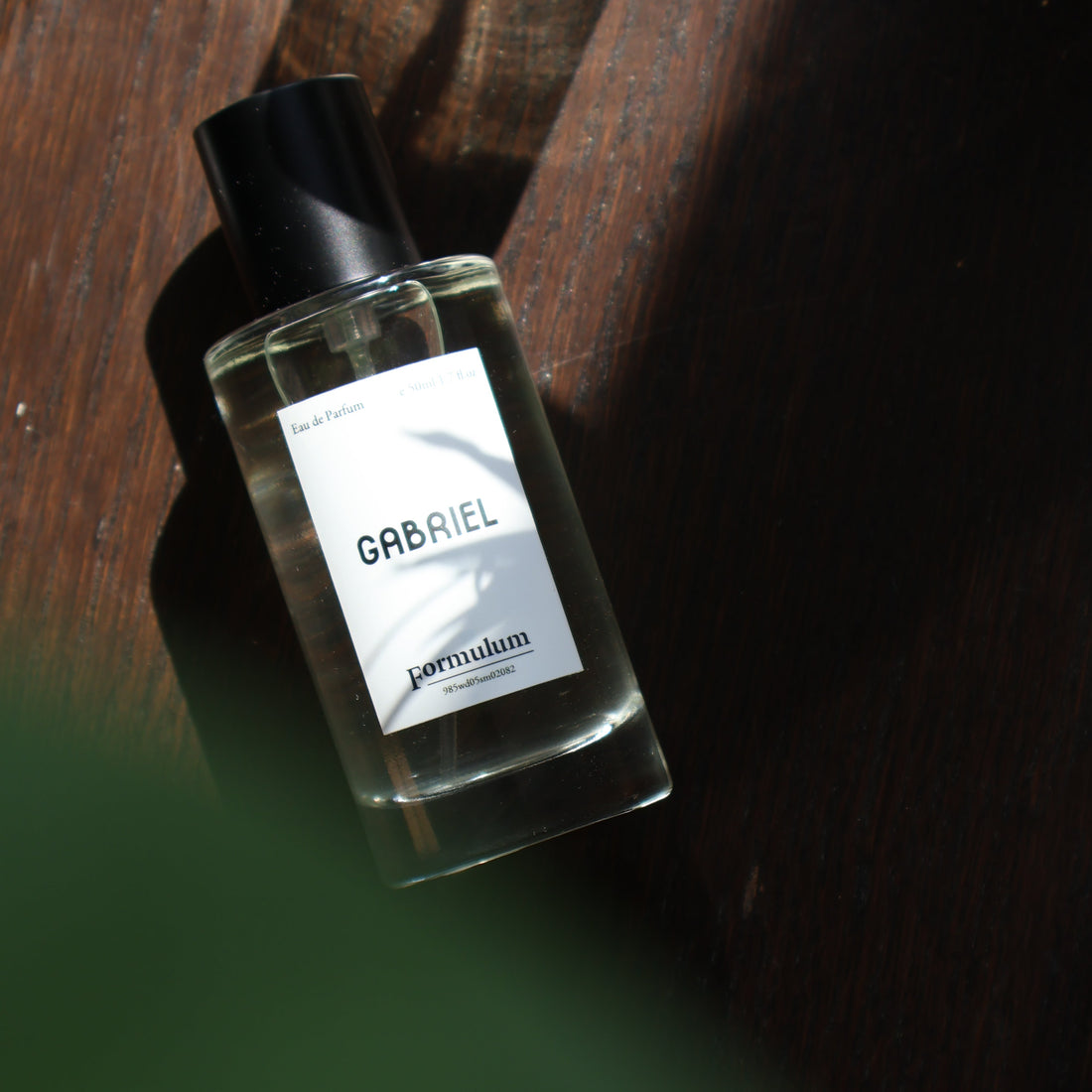 Simple People Simple Story GABRIEL Eau De Parfum 50ml by Formulum, sold at BeCandle - minimalist glass perfume bottle with white label and black cap on wooden surface.
