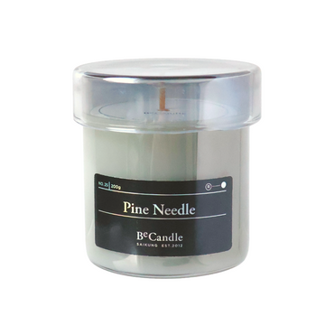 Candle in a clear container with a black label on a white background