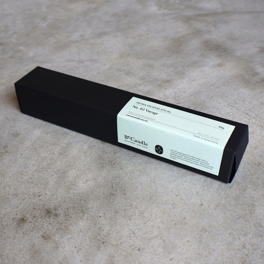 Black candle box with a label on a gray surface