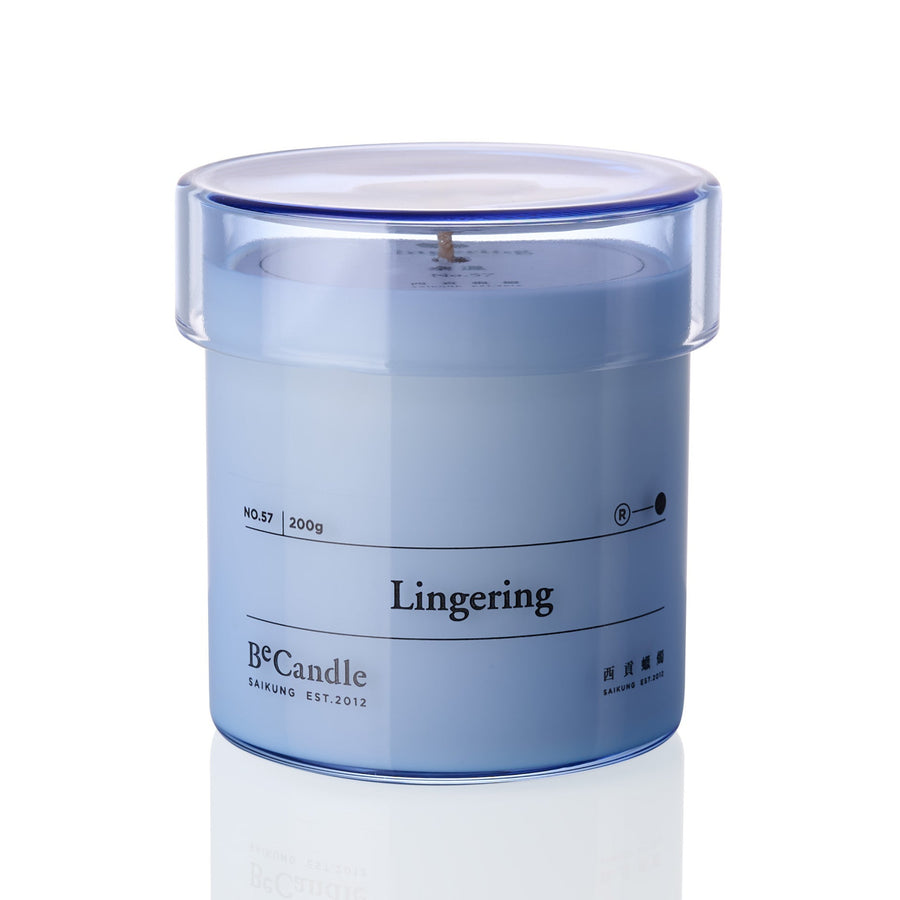 Blue candle in a transparent container labeled 'Lingering' by B&Candle on a white background